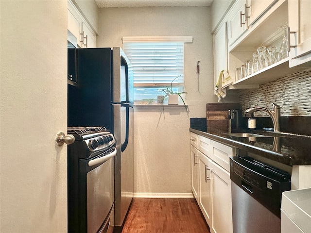 2401 Manor Rd Unit 222, Austin, TX 78722 - kitchen featuring appliances with stainless steel finishes, dark wood-style floors, baseboards, white cabinets, and dark countertops