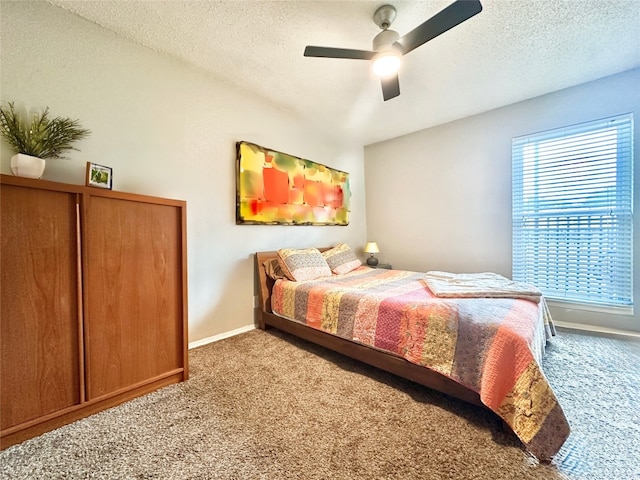 bedroom featuring ceiling fan, a textured ceiling, and carpet flooring