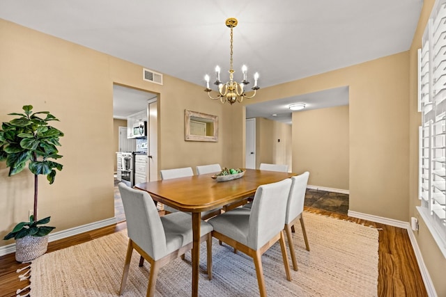 dining room featuring an inviting chandelier and dark wood-type flooring