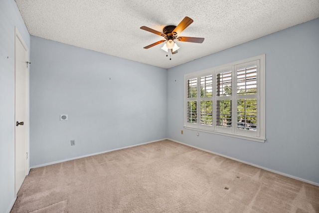 spare room with ceiling fan, light colored carpet, and a textured ceiling