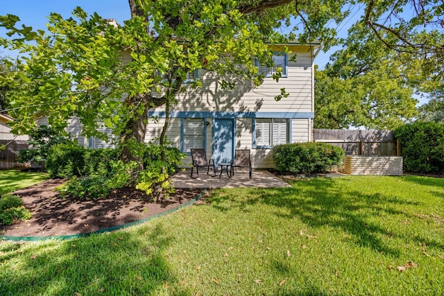 rear view of property with a lawn and a patio