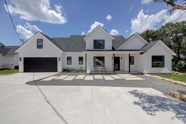 14208 Fort Smith Trl, Austin, TX 78734 - modern inspired farmhouse featuring a garage, stucco siding, covered porch, a shingled roof, and concrete driveway