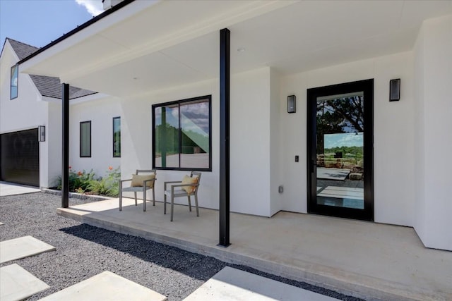 entrance to property featuring a patio area and stucco siding