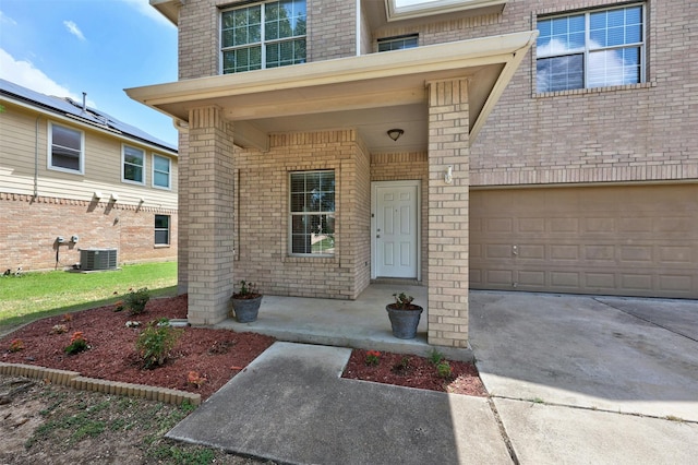 property entrance featuring central AC, a garage, and a porch