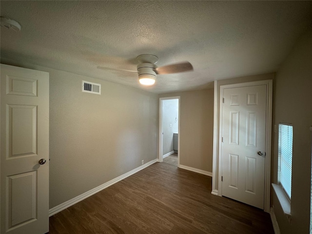 101 S Lockhart St, Manor, TX 78653 - unfurnished bedroom featuring ceiling fan, a textured ceiling, visible vents, dark wood finished floors, and baseboards
