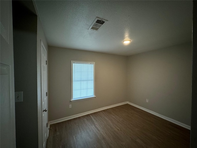 101 S Lockhart St, Manor, TX 78653 - empty room with baseboards, dark wood finished floors, a textured ceiling, and visible vents