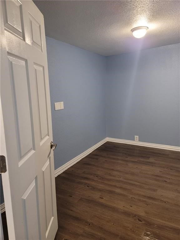 101 S Lockhart St, Manor, TX 78653 - unfurnished room with dark wood-type flooring, a textured ceiling, and baseboards