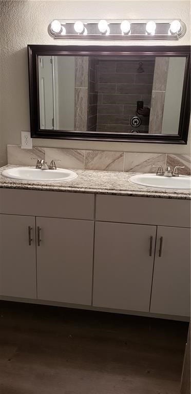 101 S Lockhart St, Manor, TX 78653 - bathroom featuring a sink, double vanity, and wood finished floors