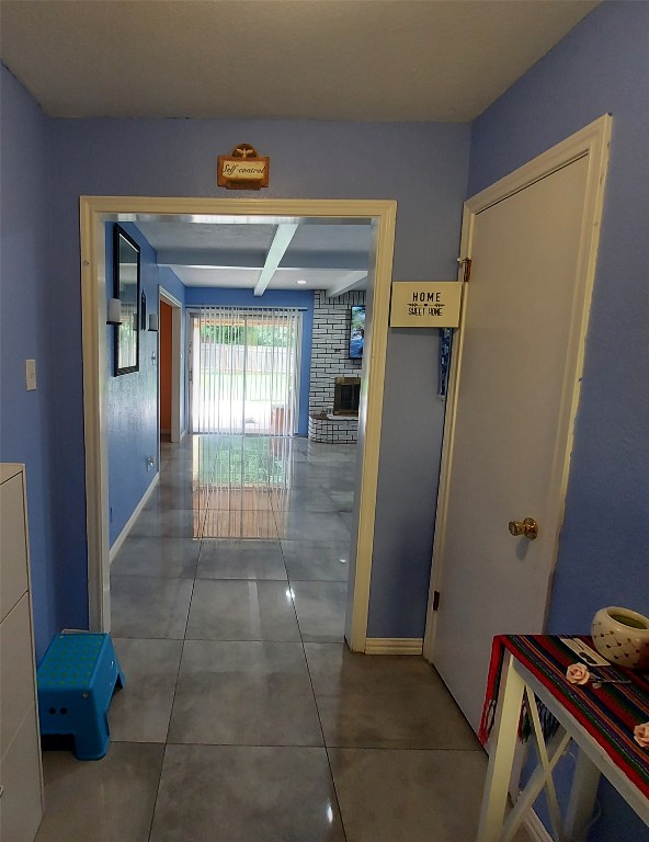 corridor featuring tile flooring and brick wall