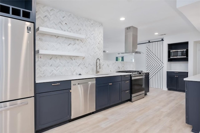 kitchen with blue cabinets, sink, light wood-type flooring, island exhaust hood, and stainless steel appliances