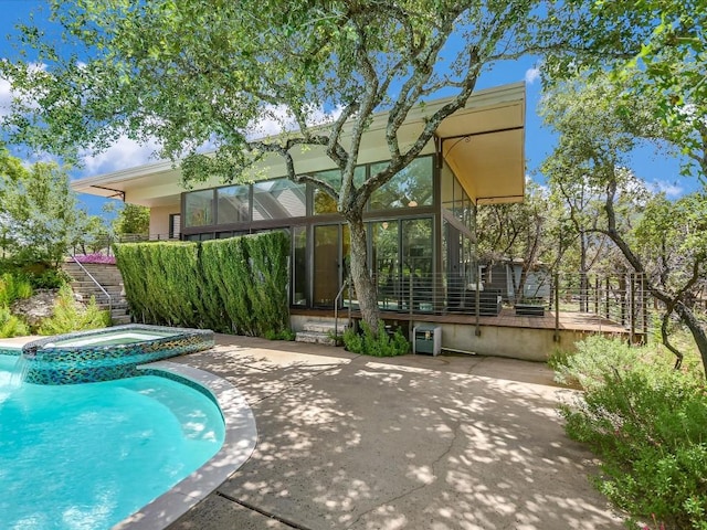 view of swimming pool featuring a patio area, an in ground hot tub, and glass enclosure