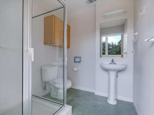 bathroom featuring toilet and a shower with shower door