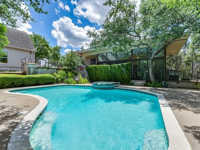 view of pool with an in ground hot tub