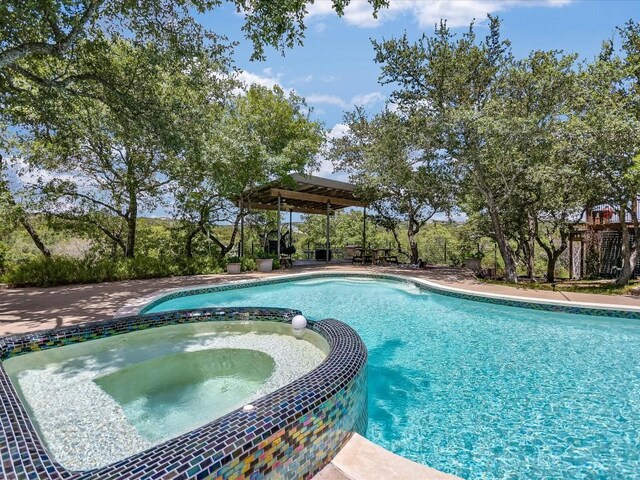 view of swimming pool with an in ground hot tub