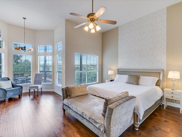 bedroom with multiple windows, dark hardwood / wood-style floors, and ceiling fan