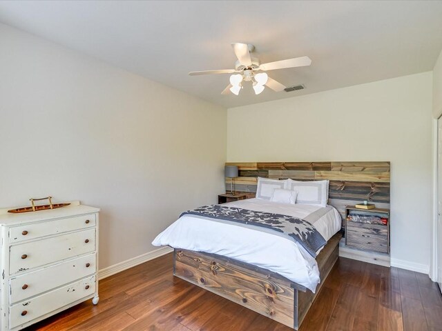 bedroom with dark hardwood / wood-style flooring and ceiling fan