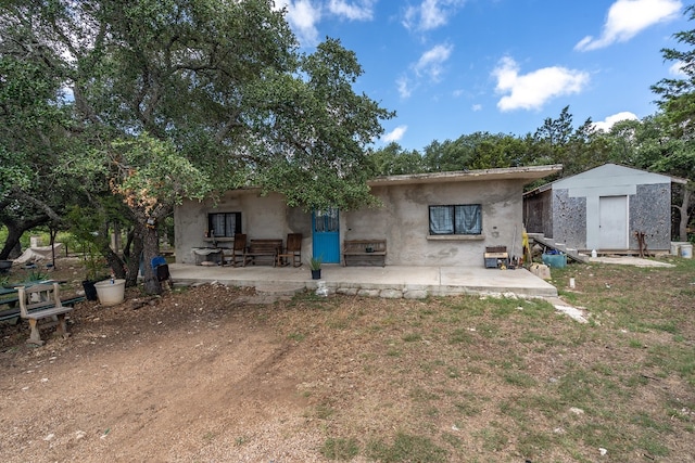 back of house featuring a patio area and a storage unit