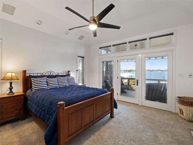 carpeted bedroom with a water view, ceiling fan, and access to exterior