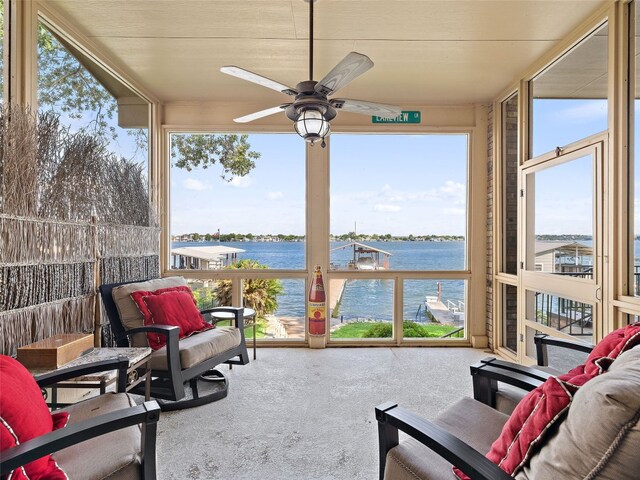 view of terrace featuring a balcony, ceiling fan, and a water view