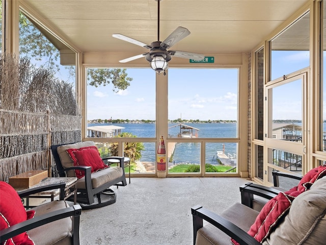 sunroom / solarium featuring ceiling fan and a water view