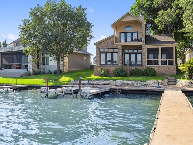 back of property with a sunroom and a lawn