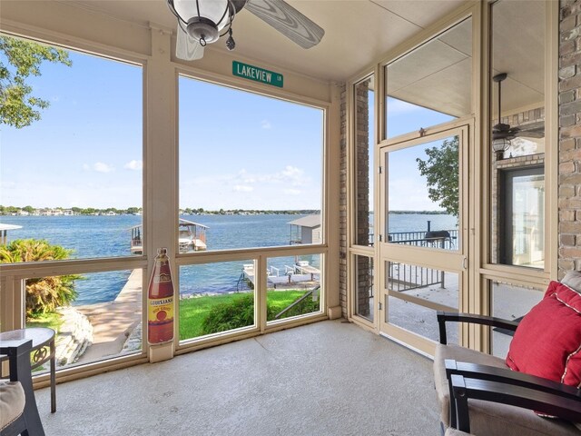 sunroom / solarium featuring ceiling fan, a healthy amount of sunlight, and a water view