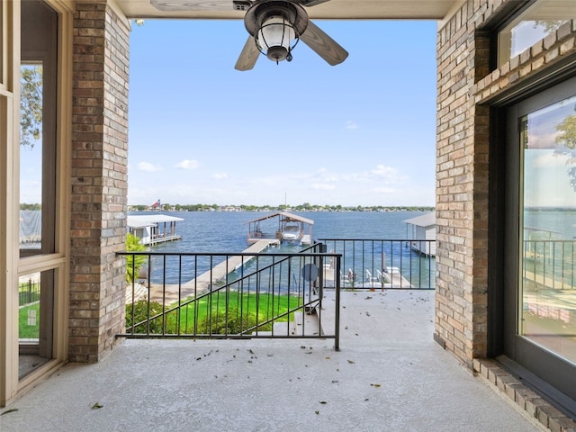 view of patio with a balcony, ceiling fan, and a water view