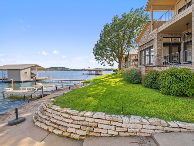 view of property's community with a boat dock, a water view, and a yard