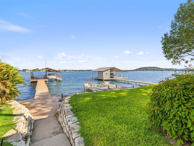 dock area with a lawn and a water view