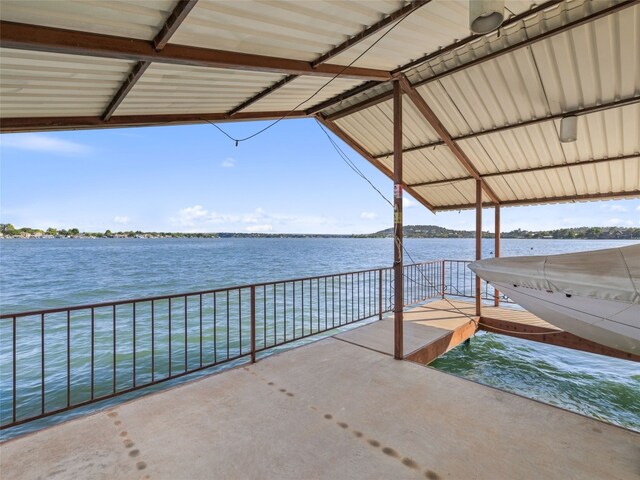 view of patio with a water view and a dock