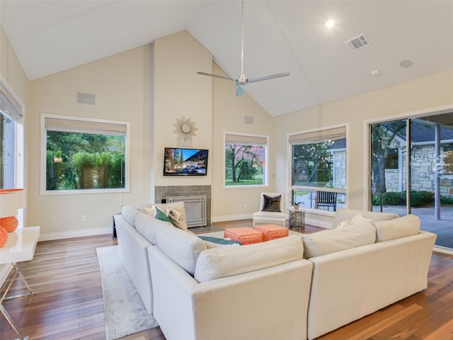 living room with ceiling fan, wood-type flooring, a fireplace, and high vaulted ceiling