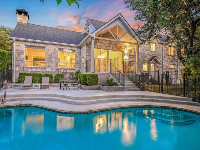 pool at dusk featuring a patio area