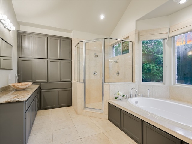 bathroom featuring tile patterned flooring, vanity, separate shower and tub, and lofted ceiling