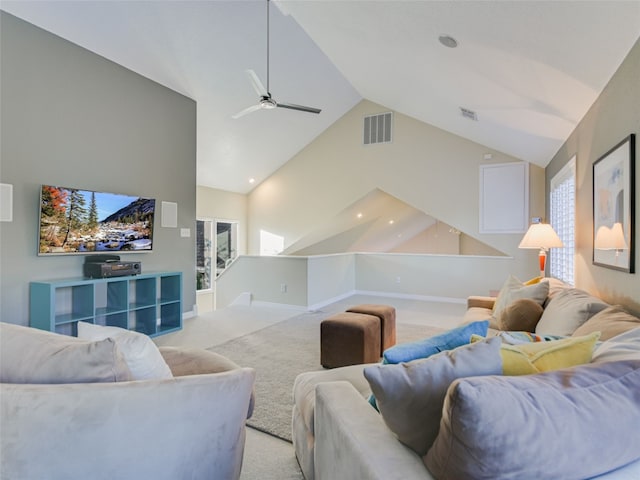 carpeted living room with ceiling fan and high vaulted ceiling