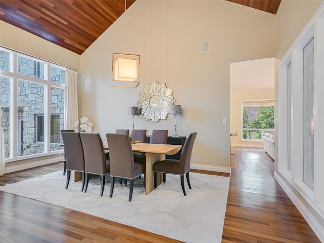 dining area with a stone fireplace, dark hardwood / wood-style flooring, wood ceiling, and high vaulted ceiling