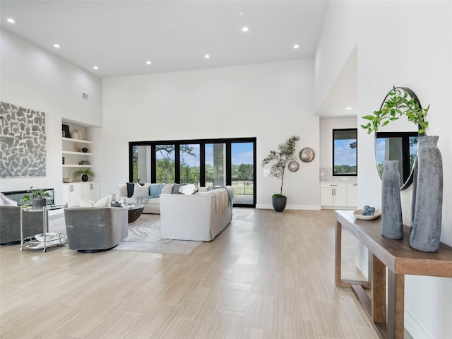 living room with a towering ceiling and built in features