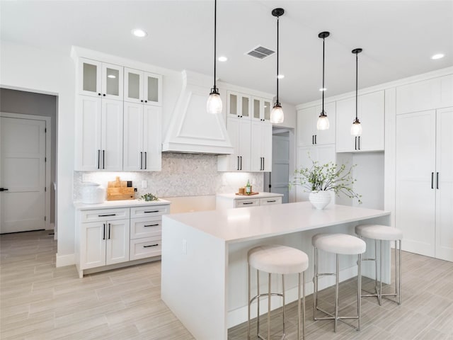 kitchen with a kitchen island, white cabinets, and decorative backsplash