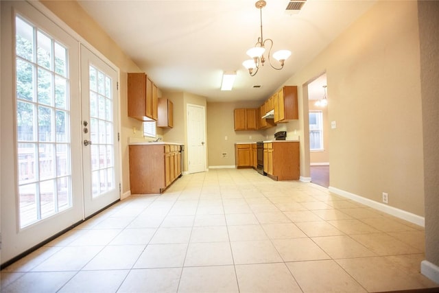 kitchen featuring french doors, pendant lighting, light tile patterned floors, an inviting chandelier, and black electric range oven