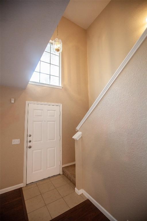 foyer entrance featuring tile patterned floors and a chandelier