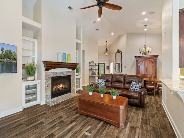 living room with dark wood-type flooring, ceiling fan with notable chandelier, and high vaulted ceiling