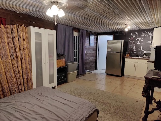 kitchen with white cabinets, stainless steel refrigerator, ceiling fan, and light tile patterned flooring