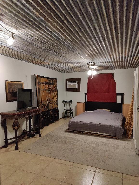 tiled bedroom with ceiling fan and a wall mounted AC