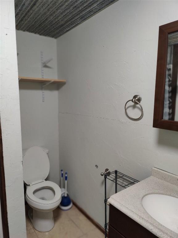 bathroom featuring tile patterned floors, vanity, and toilet