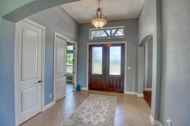 entryway with light tile patterned floors and french doors