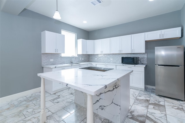 kitchen featuring a center island, stainless steel fridge, decorative light fixtures, and white cabinets