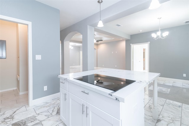 kitchen with light stone countertops, a center island, black electric stovetop, and white cabinets