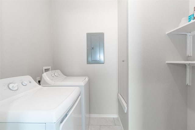 clothes washing area featuring light tile patterned floors, electric panel, and washer and clothes dryer