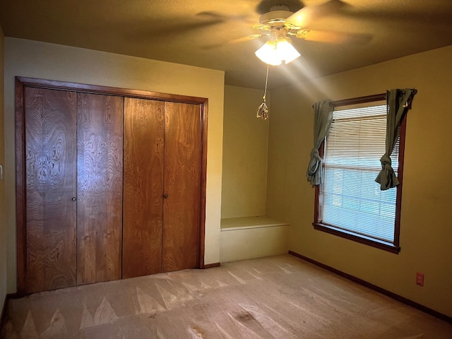 unfurnished bedroom featuring a closet, carpet flooring, and ceiling fan