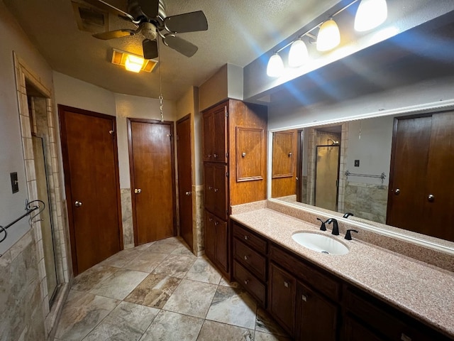 bathroom featuring vanity, tile patterned floors, ceiling fan, and an enclosed shower