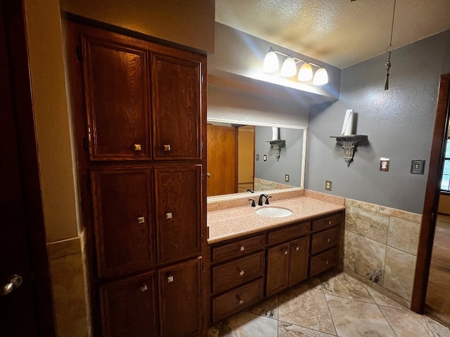 bathroom with tile patterned flooring, vanity, and a textured ceiling